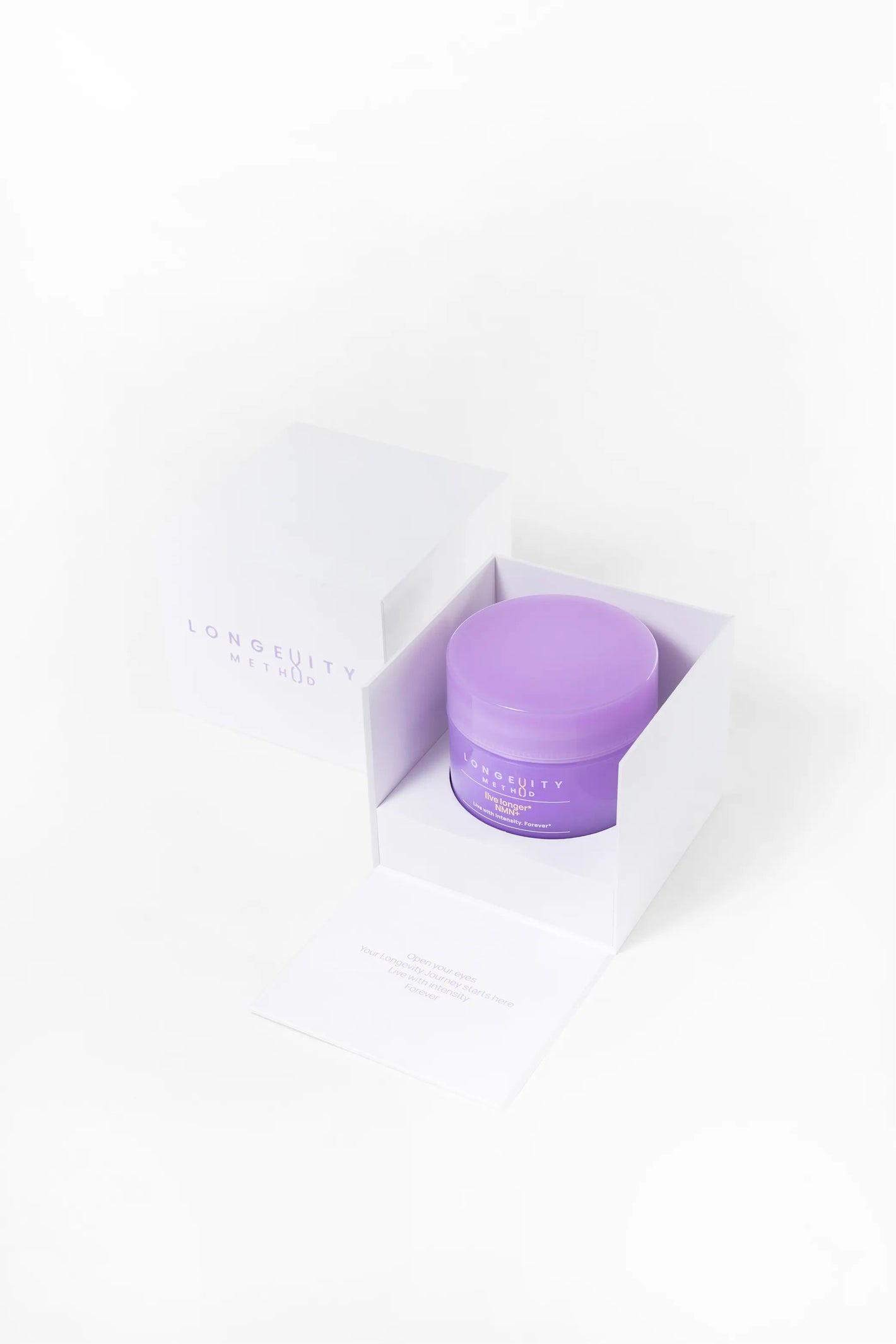 A close-up of the Longevity Method NMN+ sleek purple jar nestled in white packaging